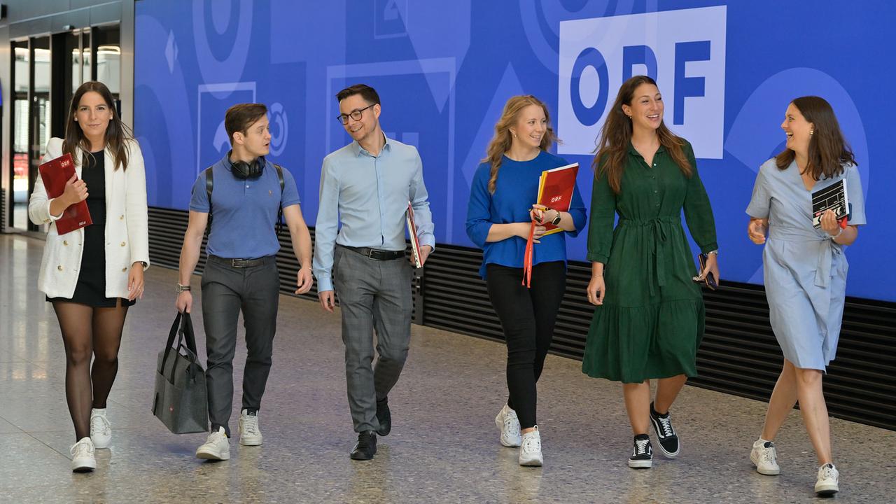 Sechs Personen spazieren durch den ORF und unterhalten sich fröhlich